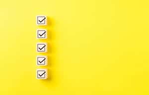 Checklist concept. Correct sign tick check mark on wooden block with copy space for the checklist on yellow background. Business survey questionnaire, Exam test process, filling digital form online,
